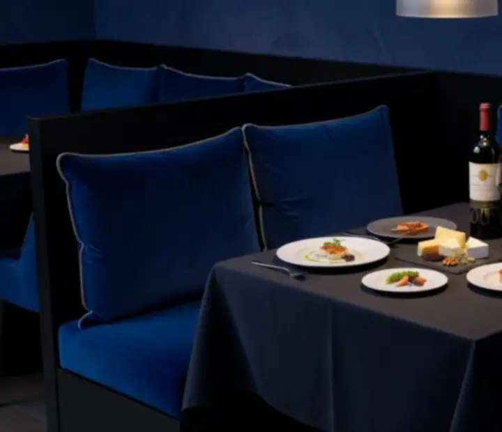 Małe dania i kieliszki wina serwowane bezpośrednio przy eleganckim stole w lounge